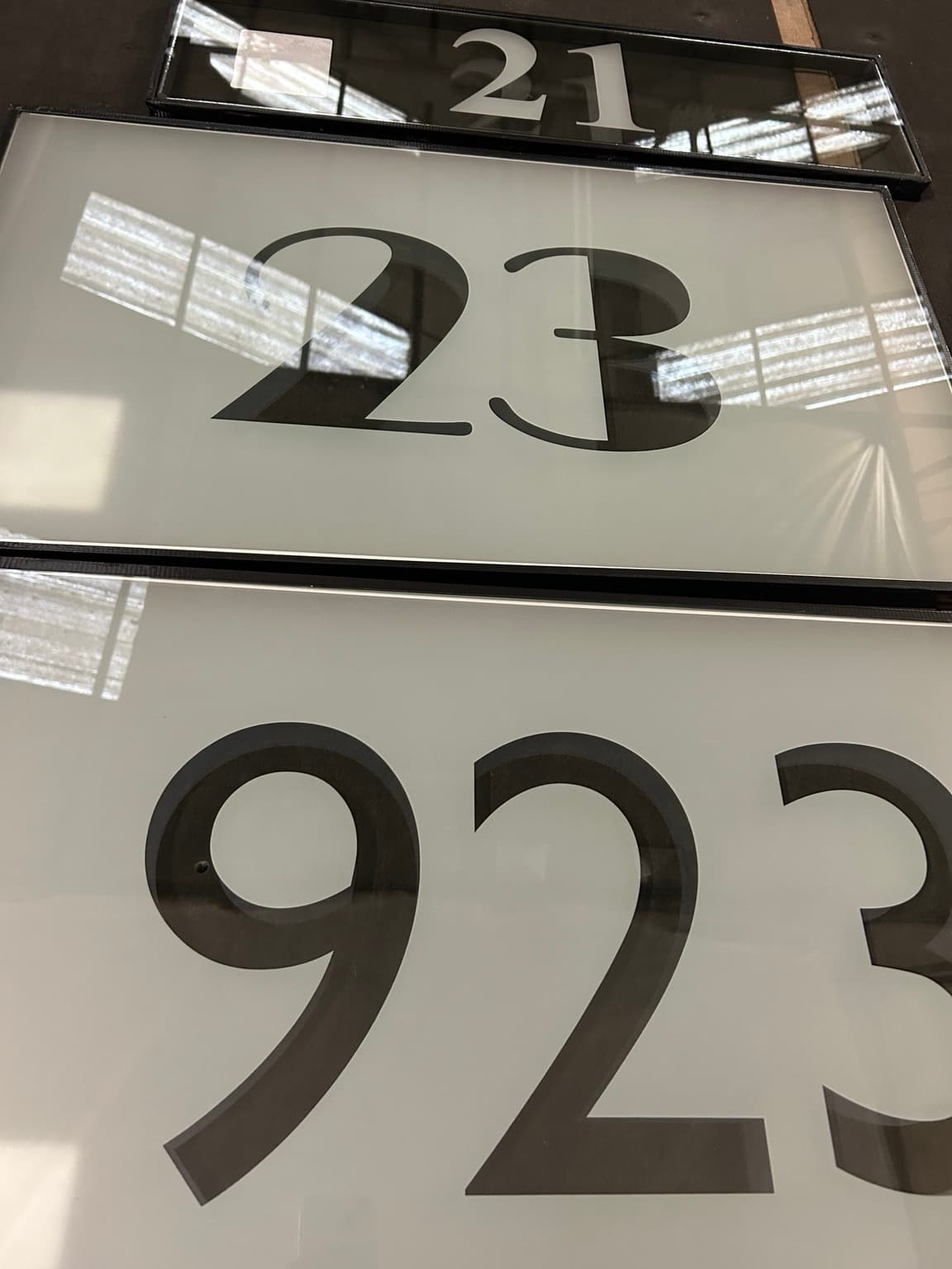 Three satin panels with the house numbers 21, 23 and 923 left clear