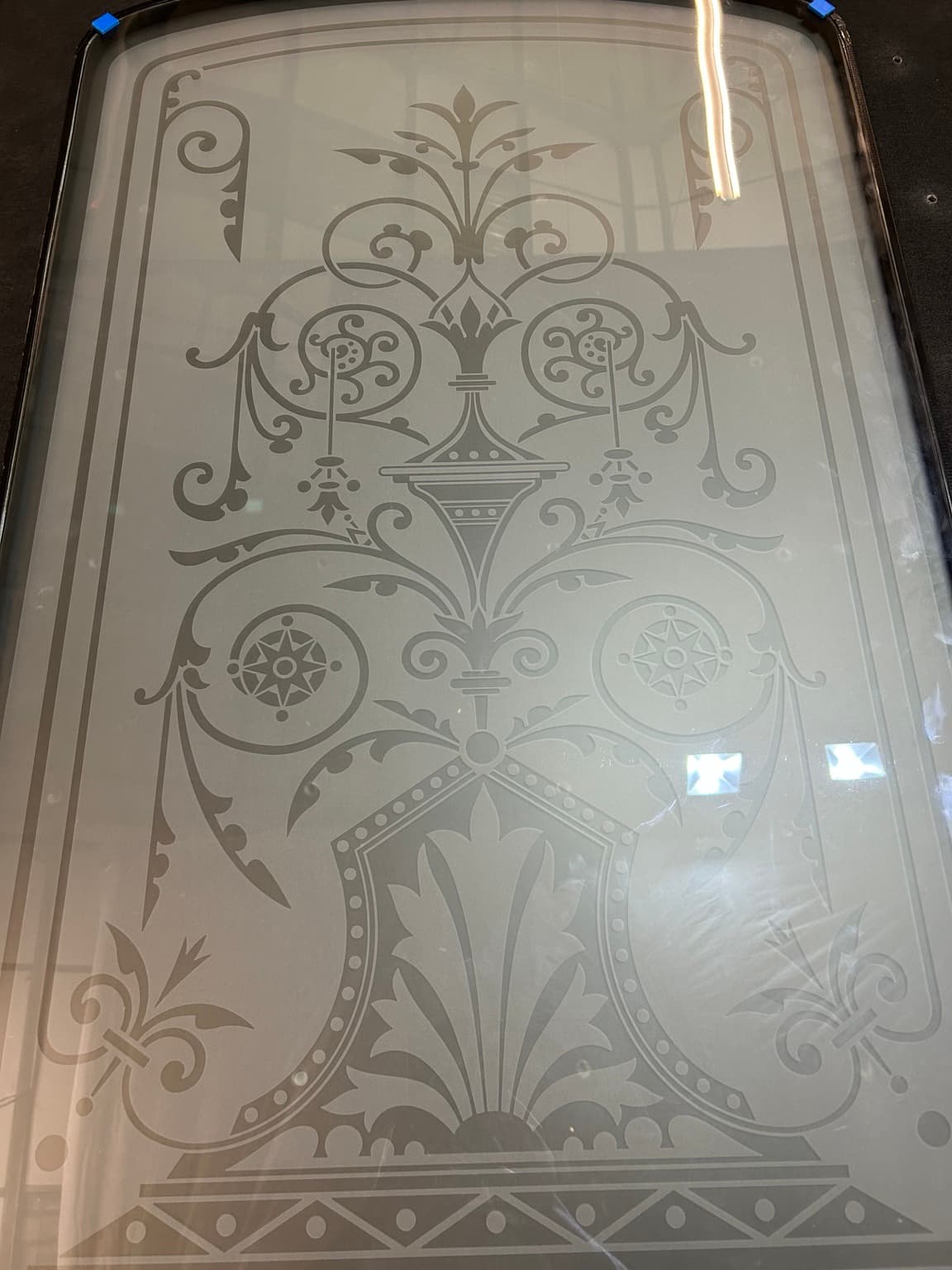 A decorative panel with scrolling foliage, rosettes and a framed border