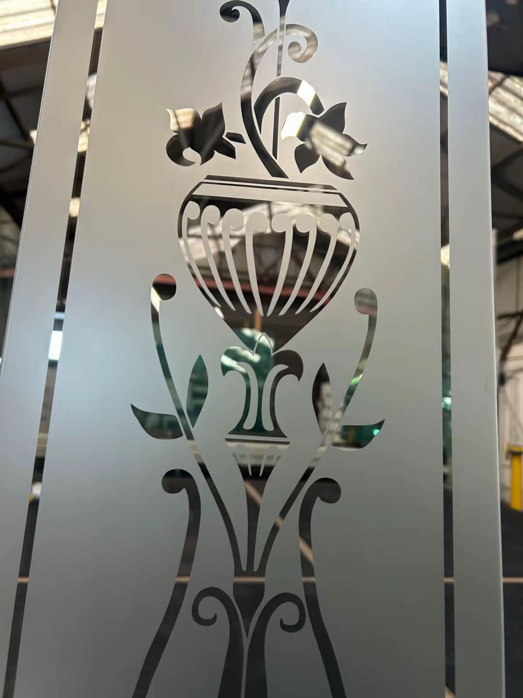 Close-up of a classical urn and flowing scrollwork left clear in satin glass
