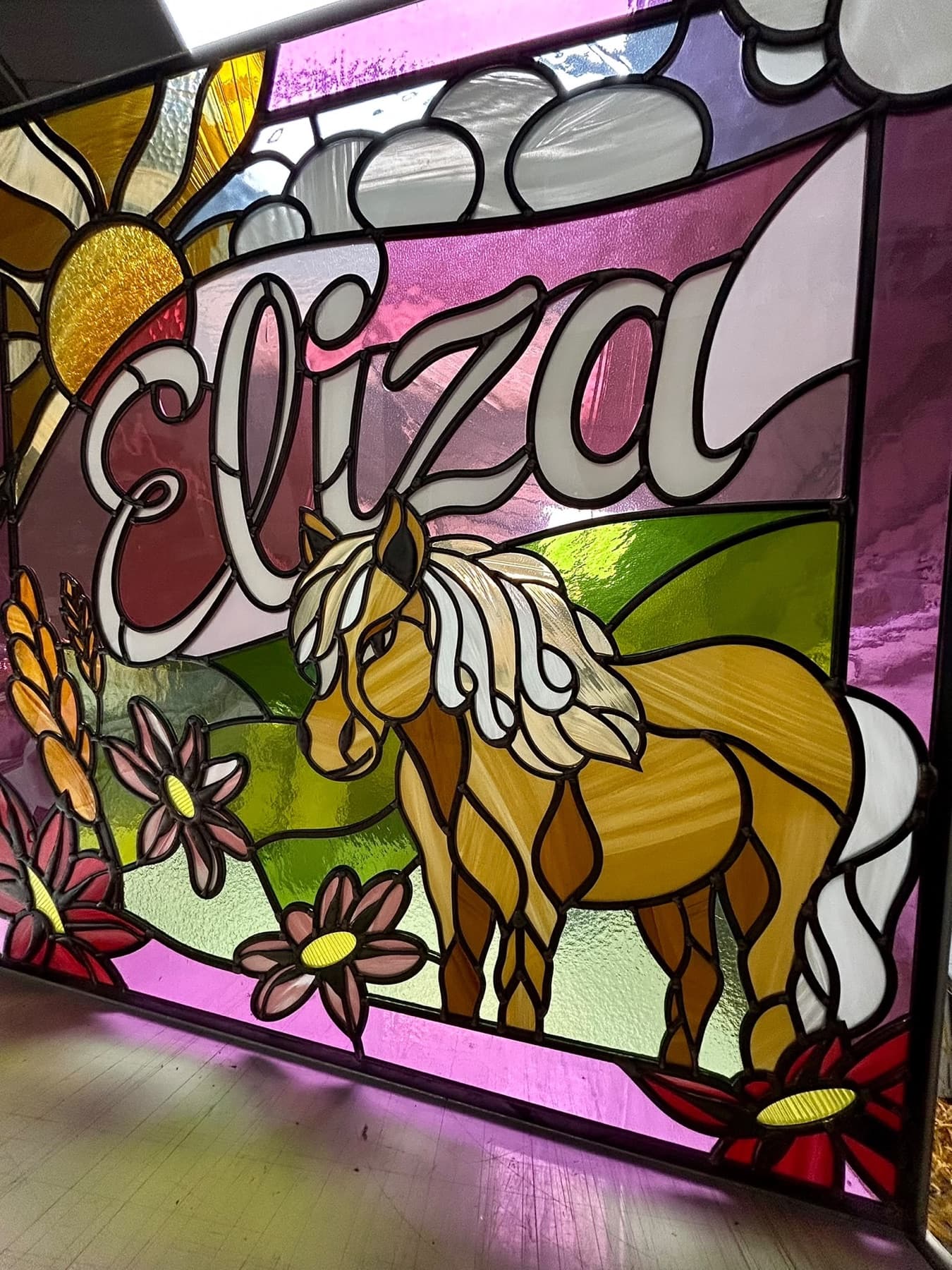 A palomino pony among pink flowers under the name Eliza, in pink and green glass