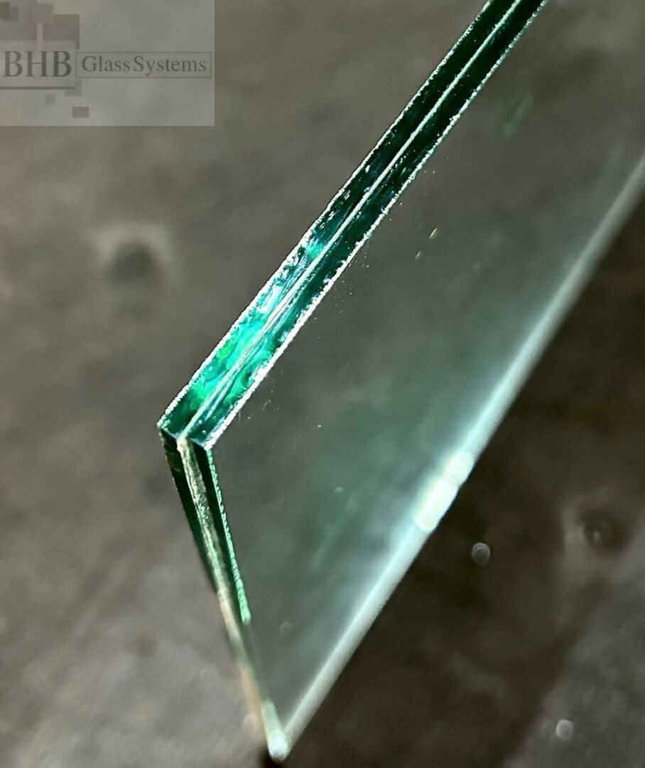 Close-up of a laminated glass edge showing the interlayer
