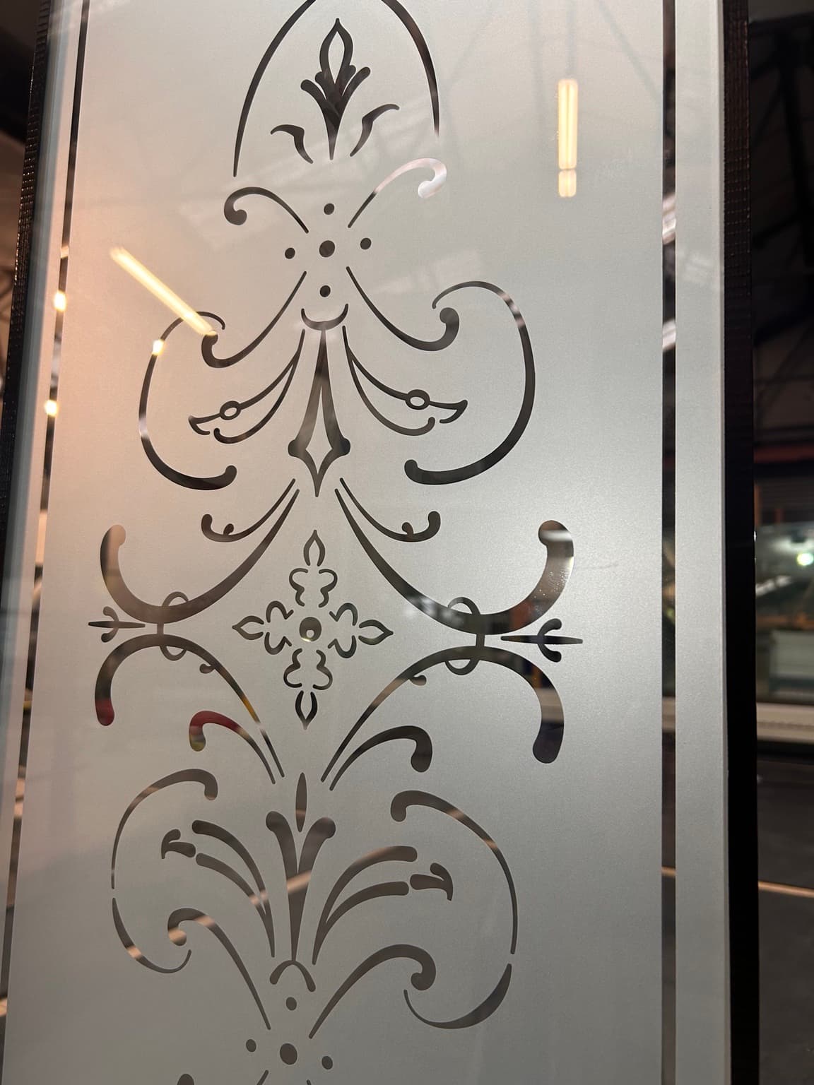 A scrolling floral design left clear in a satin-etched door panel