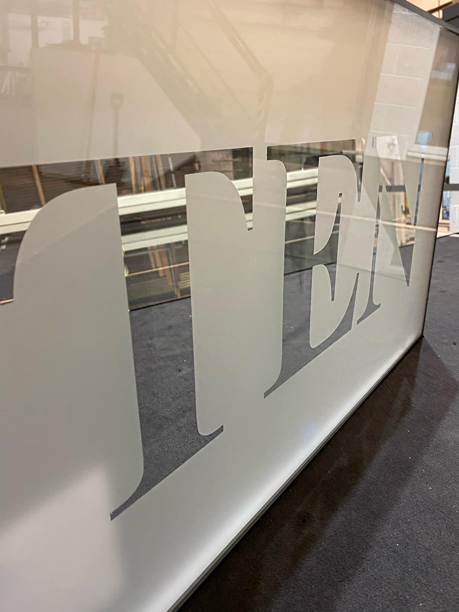 The word TEN etched into a glass panel