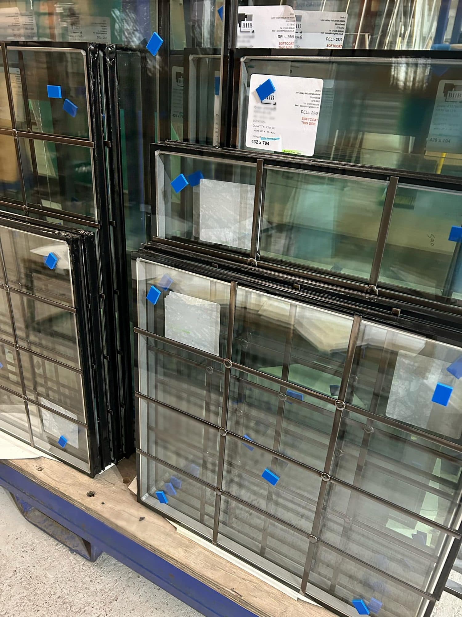 Finished sealed units stacked on a rack, each labelled for its order